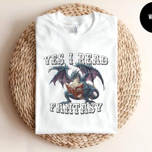 May include: White t-shirt featuring a dragon reading a book with the text "Yes I Read Fantasy".