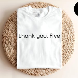 May include: White t-shirt with the text "thank you, five" printed in black.