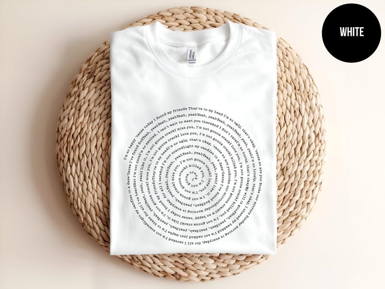 Puede incluir: Camiseta blanca con un dise&ntilde;o en espiral negro que incluye el texto "I'm so happy cause today I found my friends. They're in my head I'm so unlike that other... I'm not gonna crack, so easily. I'm not gonna break, so easily. I'm not gonna fall apart, so easily. I'm not gonna..."
