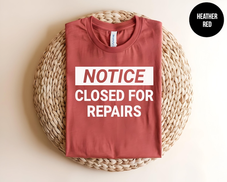 May include: Heather red t-shirt with a white graphic that says "NOTICE CLOSED FOR REPAIRS".