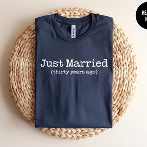 May include: A navy blue t-shirt with the text "Just Married (thirty years ago)" printed in white.