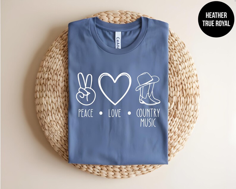 May include: A blue t-shirt with a white peace sign, heart, and cowboy boots graphic. The text "Peace Love Country Music" is printed below the graphic.