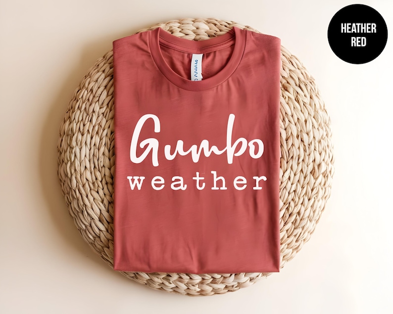 May include: A heather red t-shirt with the text "Gumbo weather" printed in white on the front.