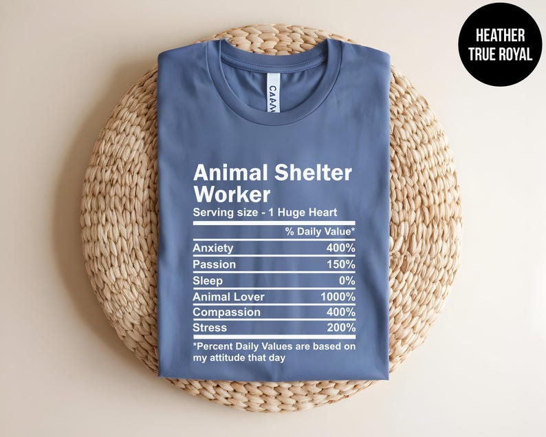 May include: A blue t-shirt with white text that reads "Animal Shelter Worker" and a nutrition label listing the daily value of anxiety, passion, sleep, animal lover, compassion, and stress. The text at the bottom reads "*Percent Daily Values are based on my attitude that day"