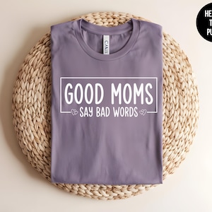 May include: Purple heather t-shirt with the text "Good Moms Say Bad Words" in white lettering.