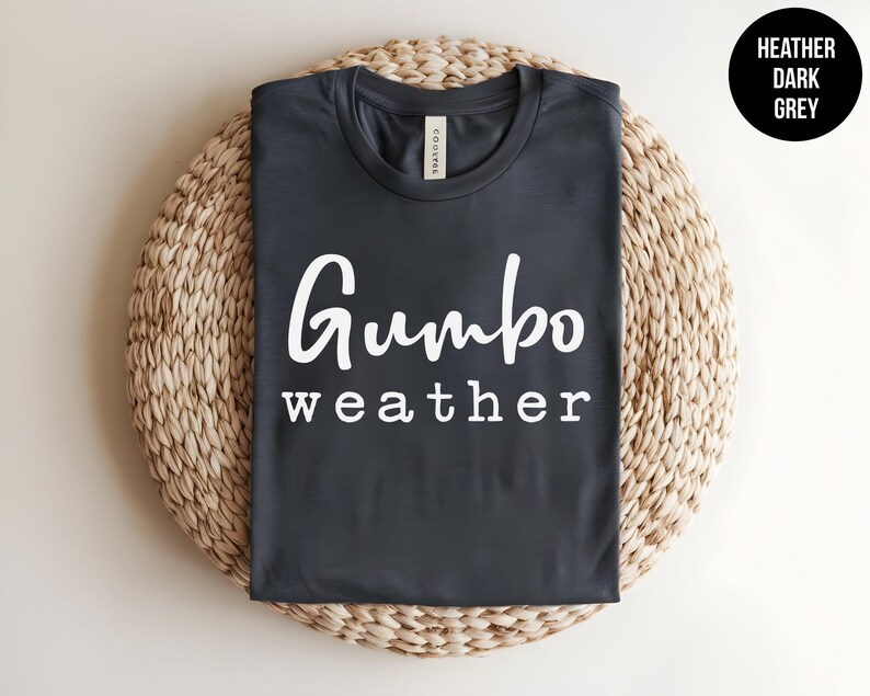 May include: A dark heather grey t-shirt with the text "Gumbo weather" printed in white.