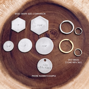 May include: A comparison of different sizes of metal tags for keychains or jewelry. The tags are round, hexagonal, and round with a split ring. The tags are made of silver metal and have measurements in inches. The image also shows a silver tag with a phone number example.