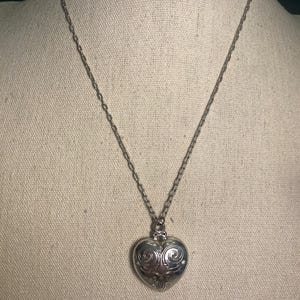 May include: A white ceramic mug with a black handle and the text "But First, Coffee" in a handwritten style. The mug is on a white surface. The mug is approximately 4 inches tall.