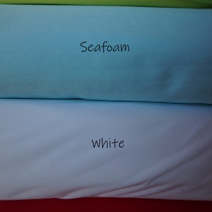 May include: Four fabric swatches stacked on top of each other. The top swatch is a bright green color labeled "Green Apple". The second swatch is a light blue color labeled "Seafoam". The third swatch is a white color labeled "White". The bottom swatch is a red color labeled "Red".