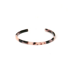 Può includere: Un braccialetto sottile a forma di bangle con un design a tartaruga in bianco e nero.