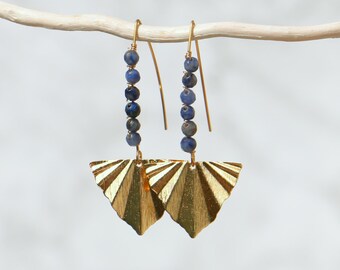 May include: A pair of gold-colored earrings with a fan-like design. Each earring features a series of blue beads suspended from a gold hook. The fan-shaped portion has a textured, ridged pattern.