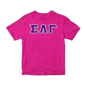 May include: A pink t-shirt with the letters "ΣΛΓ" in white with purple outlines.