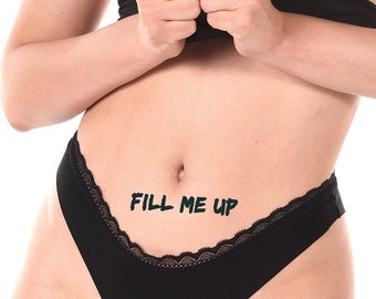 May include: Black lingerie with a lace trim and the text "FILL ME UP" printed on the front.