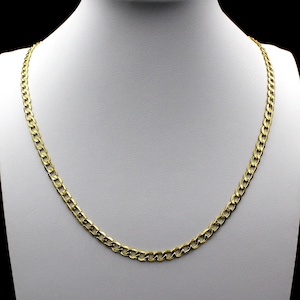 May include: A gold chain necklace with a curb link style. The chain is on a white mannequin.