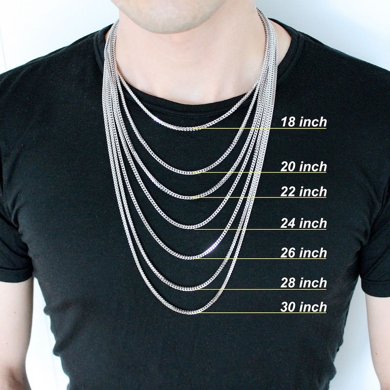 May include: A silver chain necklace in various lengths from 18 to 30 inches. The necklace is displayed on a person's neck to show the different lengths.