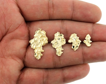 May include: Four gold nugget pendants of varying sizes. The pendants are made of 10k gold and have a textured, irregular shape.