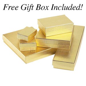 May include: A set of five gold gift boxes of various sizes. The boxes are made of cardboard and have a textured finish. The text "Free Gift Box Included!" is visible at the top of the image.