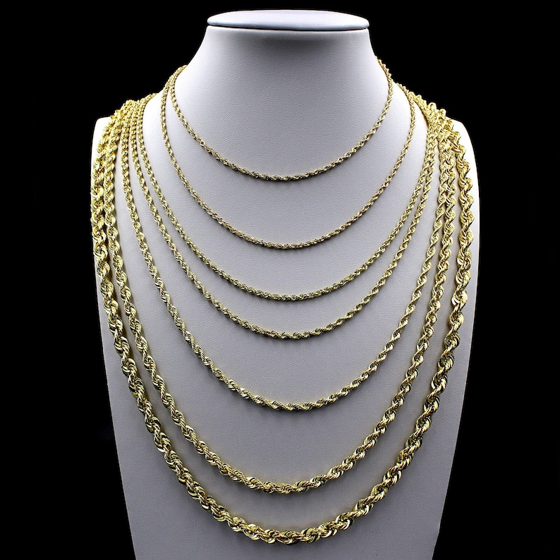 May include: A set of nine gold rope chains of varying thicknesses, displayed on a white mannequin bust.