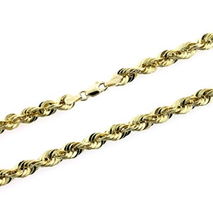 May include: A gold rope chain necklace with a lobster clasp closure.