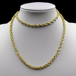 May include: Two gold rope chains on a white display stand. The longer chain is thicker than the shorter chain.