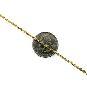 May include: A gold rope chain necklace, shown next to a US quarter for size comparison. The chain is approximately 2mm thick.