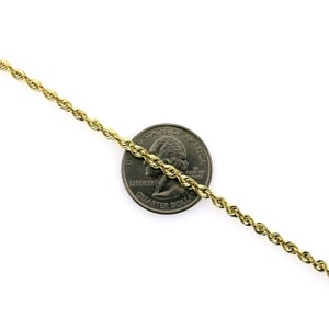 May include: A gold rope chain necklace, shown next to a US quarter dollar coin for size comparison.