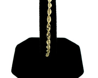 May include: A gold rope chain bracelet. The bracelet is on a black velvet display stand.
