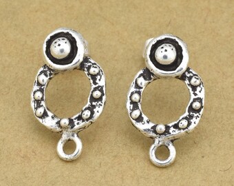 May include: A pair of silver earring findings with a circle design and a small ball at the top. The findings have a loop at the bottom for attaching a dangle.