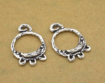 May include: Two silver-toned metal earring findings with a textured, circular design and three dangling loops.