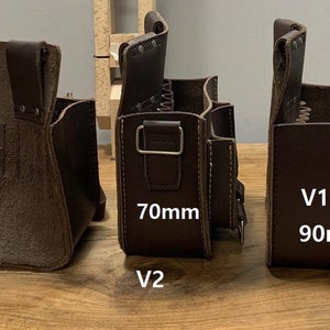 May include: Three brown leather tool bags with different sizes. The bag on the left is the smallest, the middle bag is slightly larger, and the bag on the right is the largest. The middle bag has a label that says "70mm V2" and the right bag has a label that says "90mm V1".