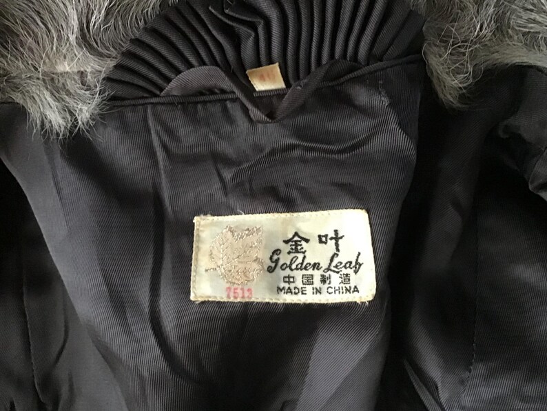May include: A black fur coat with a black satin lining and a label that reads "Golden Leaf, Made in China" in English and Chinese.