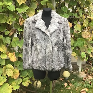 May include: A gray faux fur jacket with a collar and button closure.