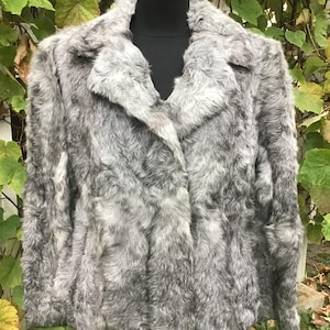 May include: A gray faux fur jacket with a collar and long sleeves.