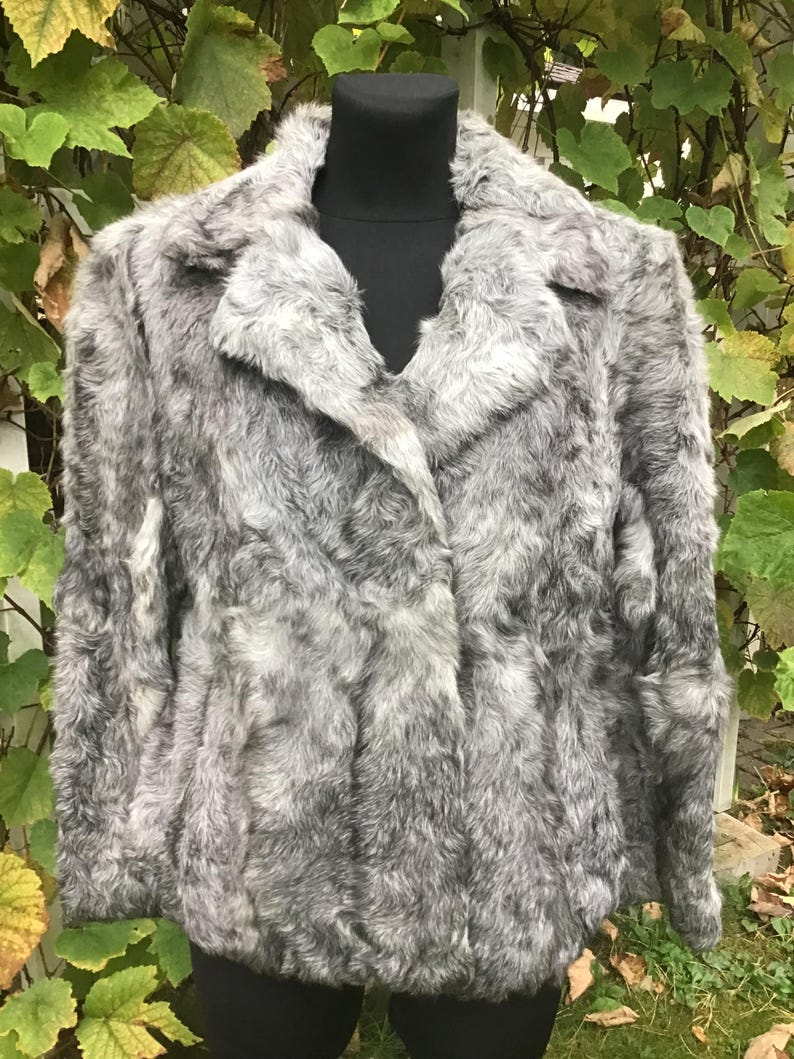 May include: A gray faux fur jacket with a collar and long sleeves.