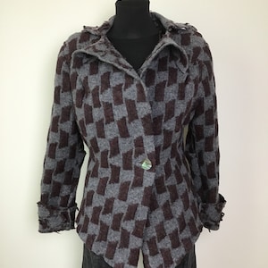 May include: A gray and brown checkered jacket with a single button closure and a hood. The jacket has a fitted silhouette and frayed edges.