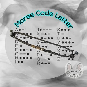 May include: A black Morse code bracelet with a gold-coloured clasp. The image includes the text "Morse Code Letter" and a chart of Morse code letters. The background is a blurred grayscale design.