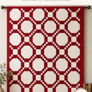 Op de afbeelding: Een quilt met een herhalend geometrisch patroon van witte achthoeken omringd door een dieprode rand. De tekst luidt BALL AND CHAIN, LAP | THROW | TWIN, DESIGNED BY MERCEDES ROSE, SOMETHING FROM NOTHING en confident beginner friendly.