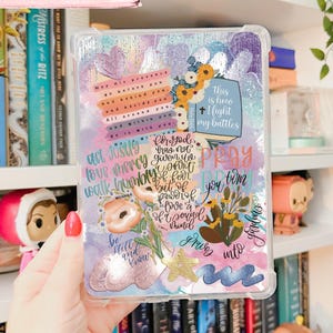May include: A clear phone case with a colorful, watercolor-style design featuring floral and inspirational text. The case includes the word "Printable" and the phrase "Free Insert Included". The design incorporates various colors and decorative elements.