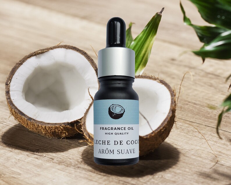 May include: A small glass bottle of coconut fragrance oil with a silver cap and dropper. The bottle is labeled "FRAGRANCE OIL HIGH QUALITY LECHE DE COCO AROM SUAVE". The bottle is sitting on a wooden surface with two halves of a coconut.