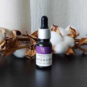 Op de afbeelding: Een klein zwart flesje met een zilveren dop en een paars label met de tekst "FRAGRANCE OIL HIGH QUALITY LAVENDER AROM SUAVE".