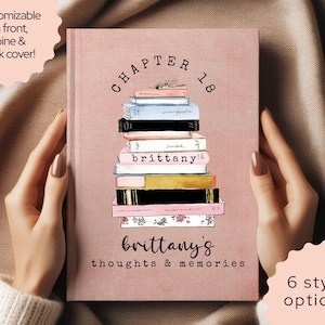 May include: A pink journal with a stack of books illustration. The cover reads "CHAPTER 18" above the book stack and "brittany's thoughts & memories" below. The journal is customizable on the front, spine, and back cover.
