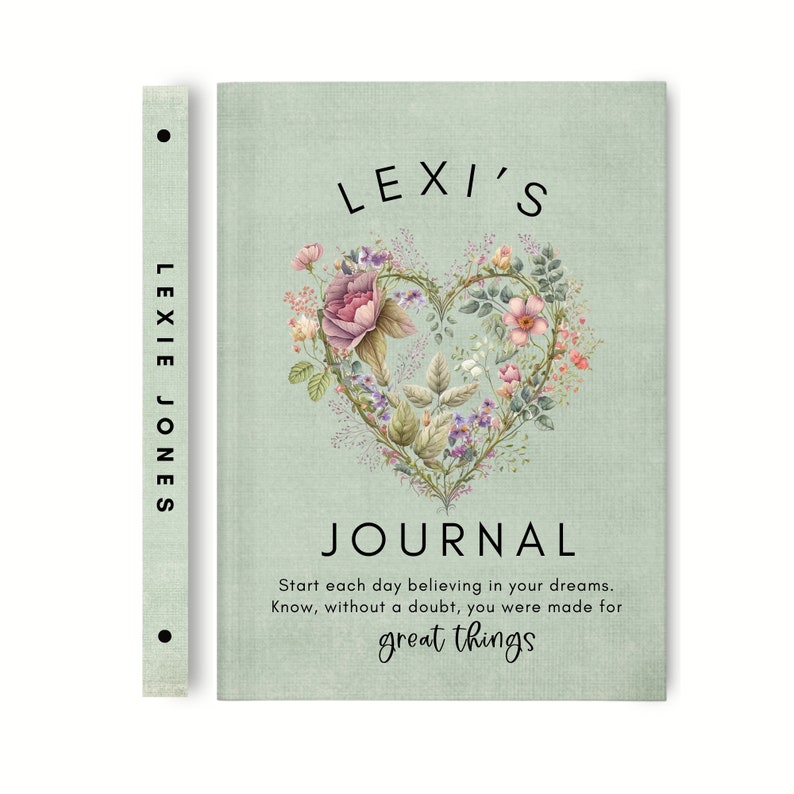 May include: A light green journal with a textured cover featuring a heart-shaped floral illustration. The text reads: LEXI'S JOURNAL, Start each day believing in your dreams. Know, without a doubt, you were made for great things. The spine says LEXIE JONES.