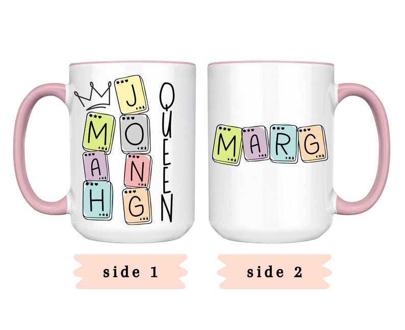 May include: White ceramic mug with a pink handle and rim. One side features the text "J MONAHG QUEEN" in colorful letter blocks with a crown. The other side displays "MARG" in similar blocks. "Side 1" and "Side 2" are written below.