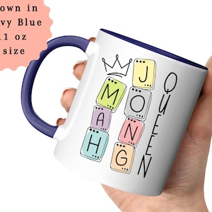 May include: White ceramic mug with a navy blue handle and rim. The mug features the text "MATH QUEEN" in a playful font, with each letter inside a colorful square. The mug is 11 oz.