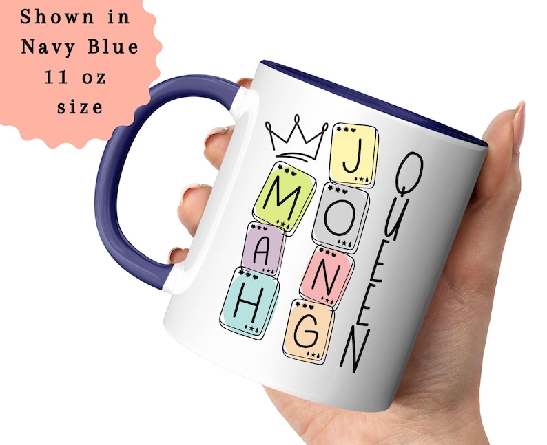 May include: White ceramic mug with a navy blue handle and rim. The mug features the text "MATH QUEEN" in a playful font, with each letter inside a colorful square. The mug is 11 oz.