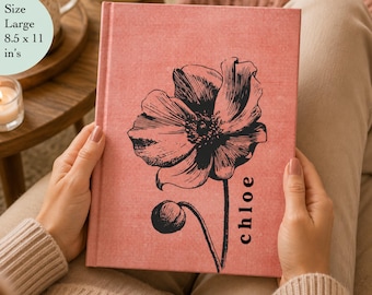 May include: A large 8.5 x 11 inches hardcover book with a textured dusty rose fabric cover. The front features a black line-art illustration of a blooming poppy flower with a bud and the name chloe printed vertically in a simple black font.