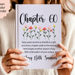 May include: A white book cover with the text "Chapter 60" in a script font, adorned with a row of colorful flowers. The cover also includes a personalized message and the name "Mary Beth Sanders."
