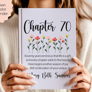 May include: A white book cover with the words "Chapter 70" in black script, adorned with a floral design. The text "Seventy years remind us that life is a gift" is also visible. The book is shown in lavender color.