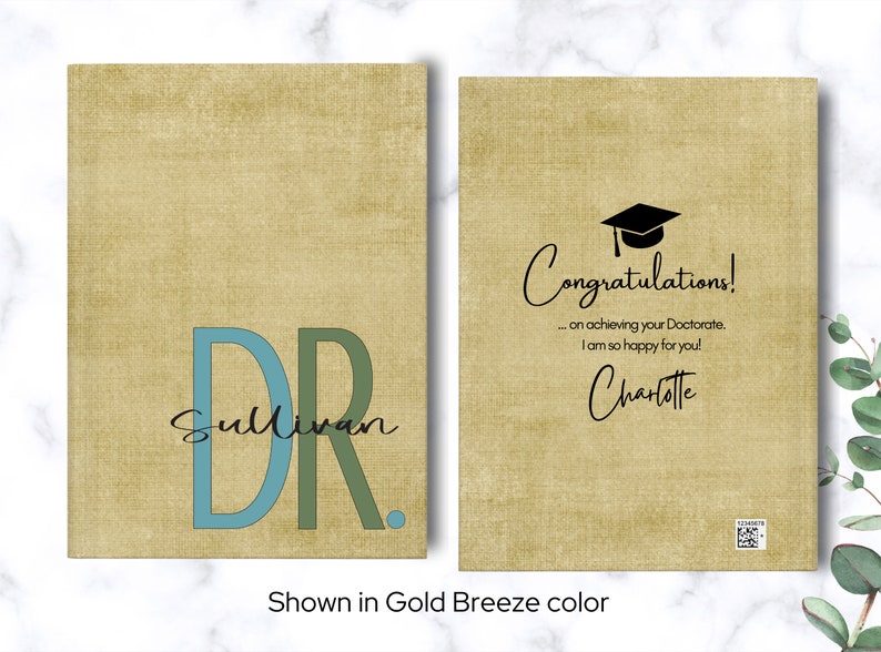 May include: A graduation card with a gold background and a black graduation cap. The card says "Congratulations! ... on achieving your Doctorate. I am so happy for you! Charlotte". The front of the card has a blue and green "DR" with the name "Sullivan" underneath.