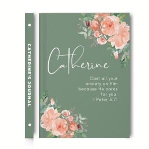 May include: A sage green journal with a floral design and the name "Catherine" written in white script. The quote "Cast all your anxiety on Him because He cares for you. 1 Peter 5:71" is printed in white text. The spine of the journal has the words "CATHERINE'S JOURNAL" printed in white.